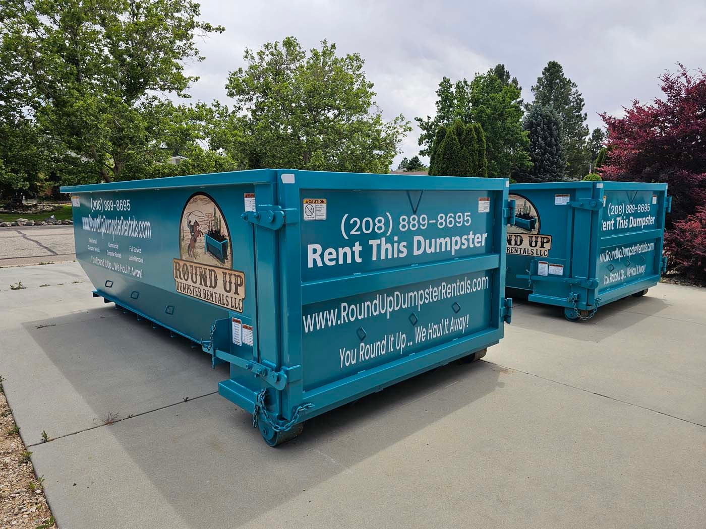 Two 20-yard roll-off dumpsters side by side on a residential driveway in Boise