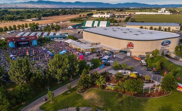 Aerial view of Ford Idaho Center in Nampa Idaho hosting outdoor event with mountain backdrop